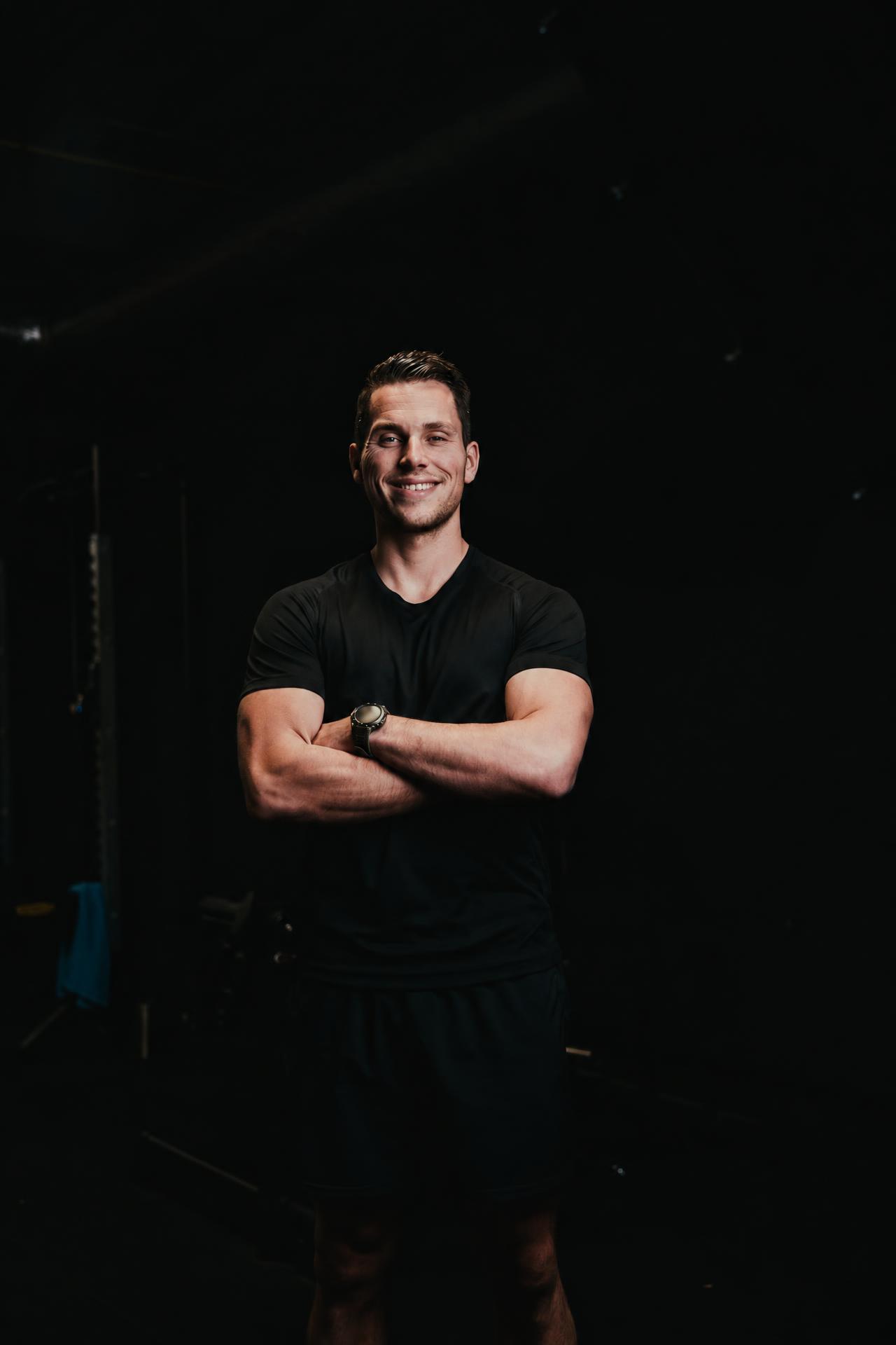 Coach van Prime Years staat met gekruiste armen in de gym
